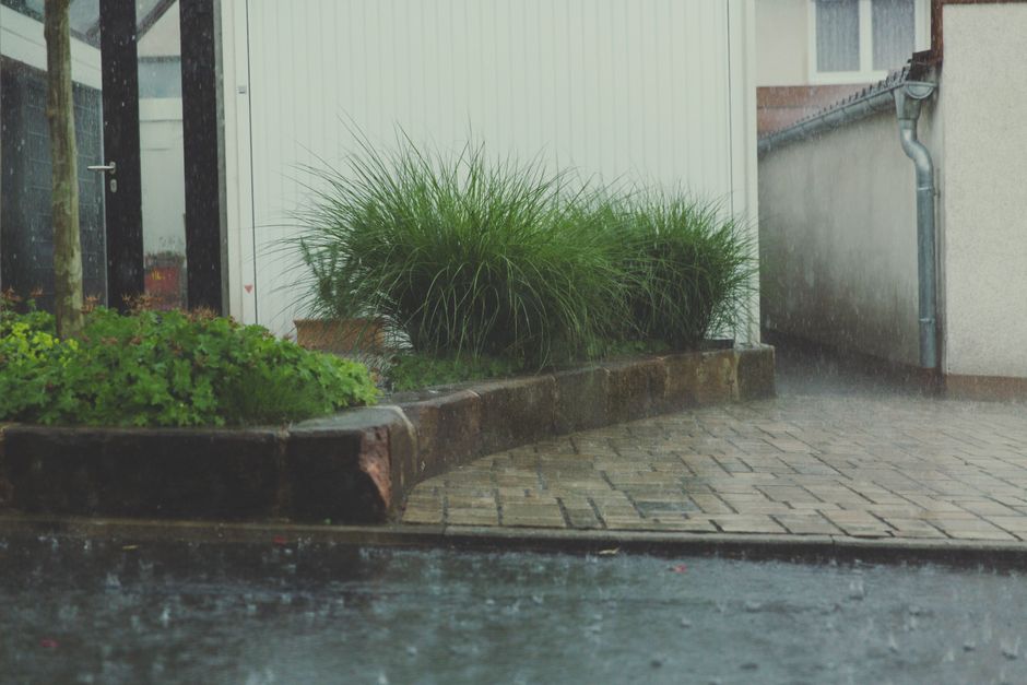 Person placing sandbags by door for rainfall.